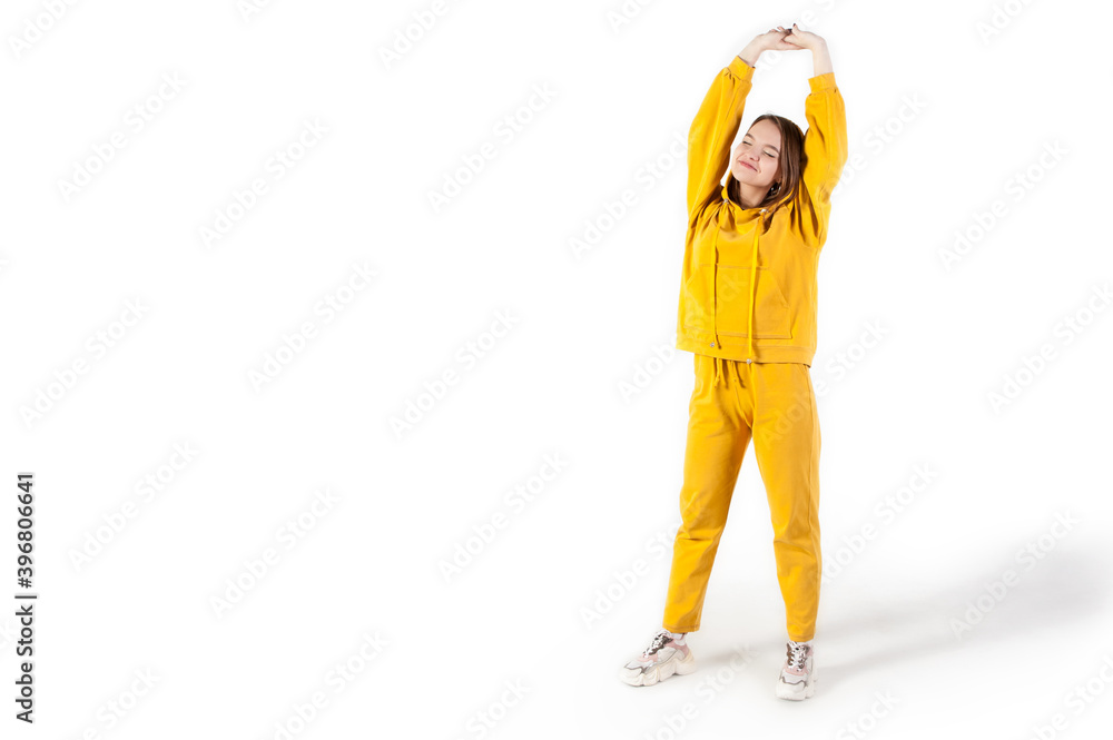 Teenager girl in yellow tracksuit on white background express emotions