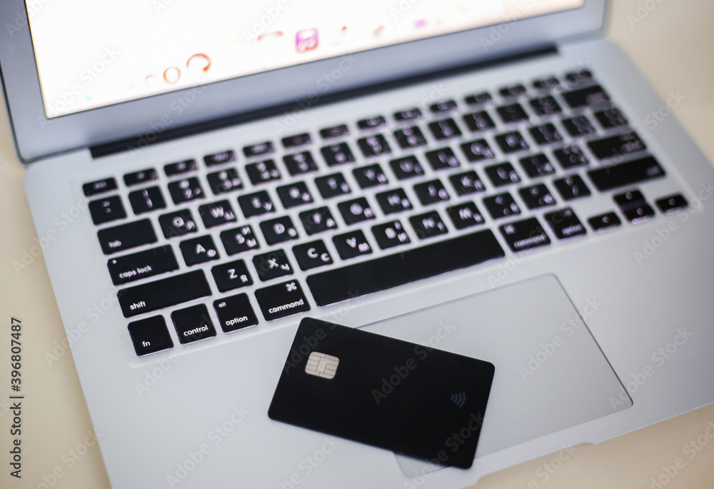laptop on a table, credit card on laptop laptop on a table, credit card on laptop