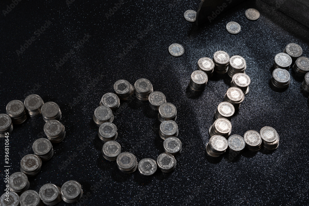 High angle view of New Years 2021 as Swiss coins on a black background. High angle view of New Years 2021 as Swiss coins on a black background.