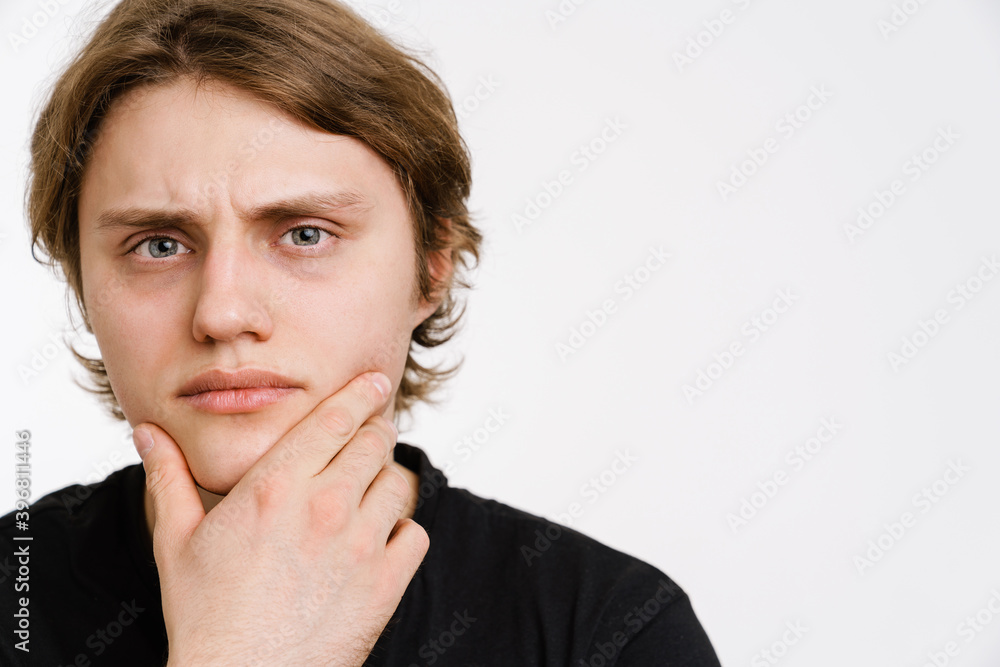 Pensive young man thinking isolated over background Pensive young man thinking isolated over background