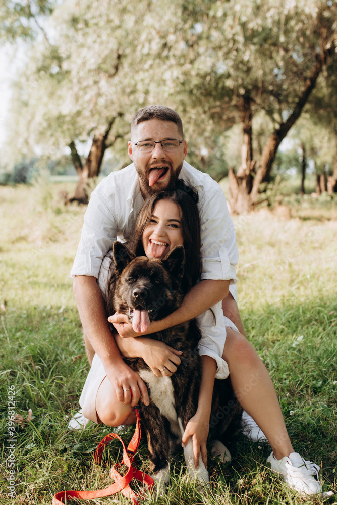 American Akita dog for a walk with a guy and a girl American Akita dog for a walk with a guy and a girl