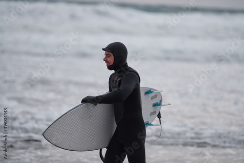 Photography Arctic surfer going by beach after surfing