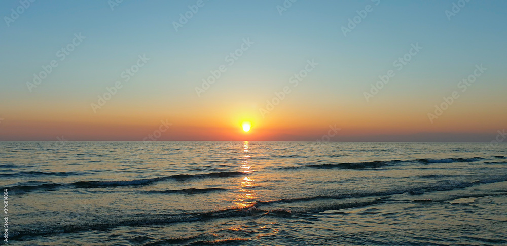 Obraz premium Sea sunset. The sun sets over the horizon of the sea.