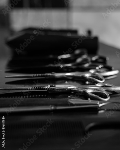 Black and white close up of hair barber equipment in the a queues on the table. Barber shop tools