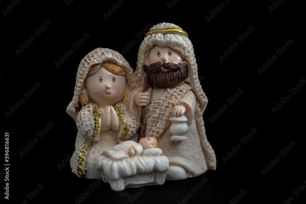 Fototapeta premium Representation of a Christmas nativity scene with the figures of baby Jesus, Mary and Joseph on a black background. Christmas concept.