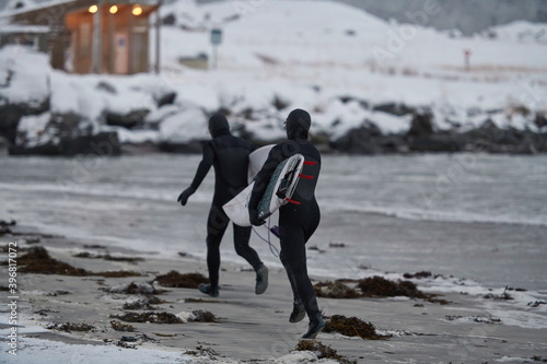Photography Arctic surfers running on beach after surfing