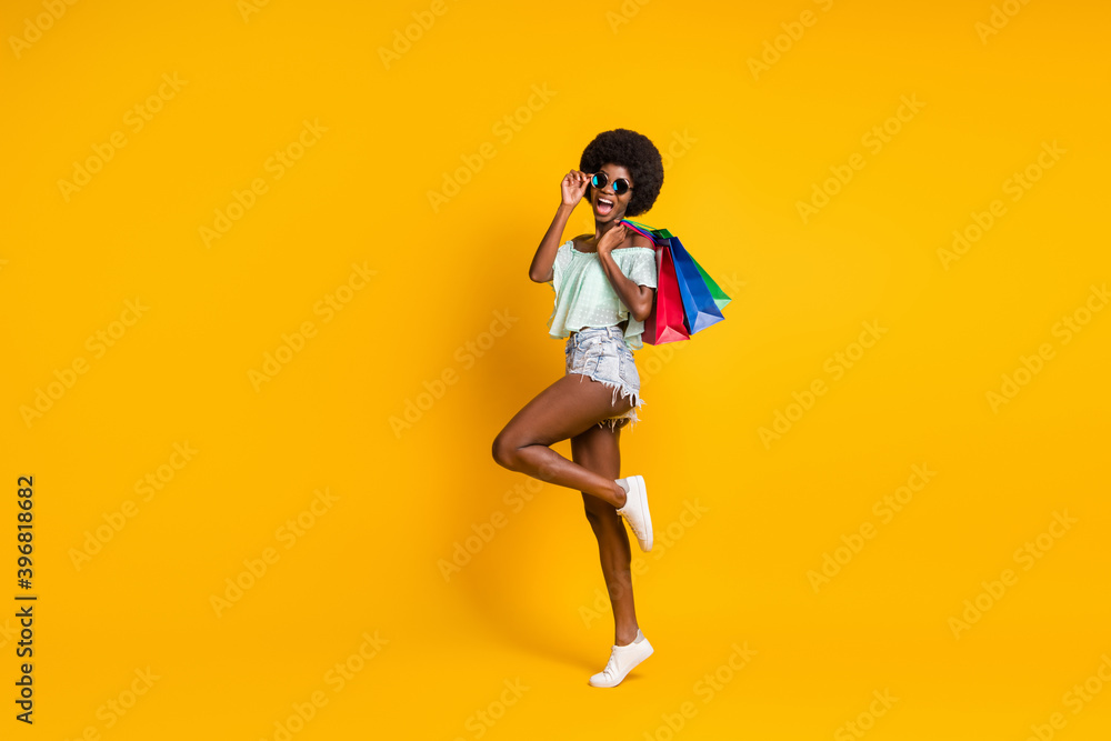 Full length body size photo of black skinned girl holding packages sale black friday isolated on vibrant yellow color background copyspace