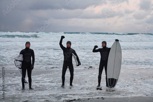 Arctic surfers going by beach after surfing