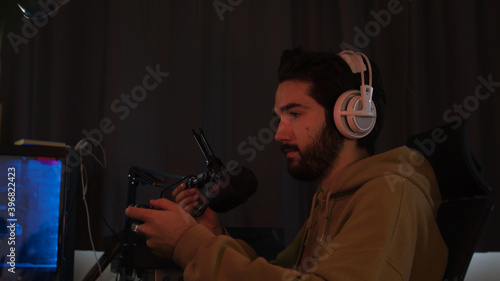Male gaming with a game pad trying hard and celebrating erratically 