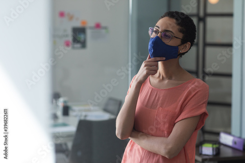 Mixed race woman wearing mask in an office