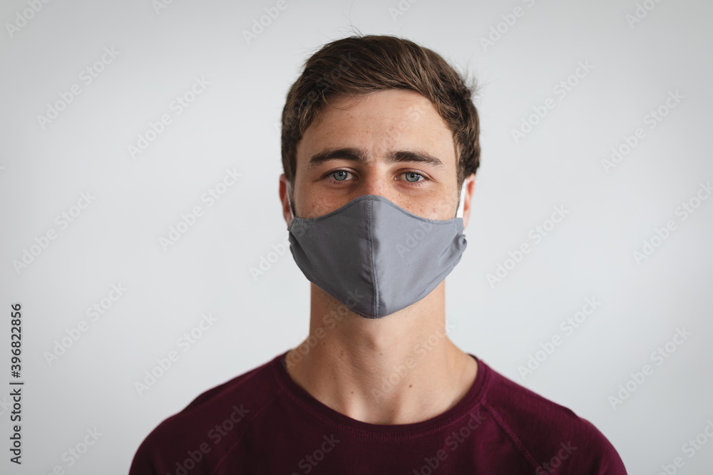 Portrait of caucasian man wearing face mask against grey background Portrait of caucasian man wearing face mask against grey background