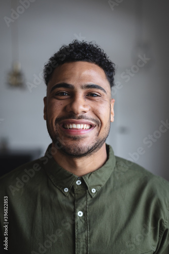 Portrait of middle eastern man smiling against grey background
