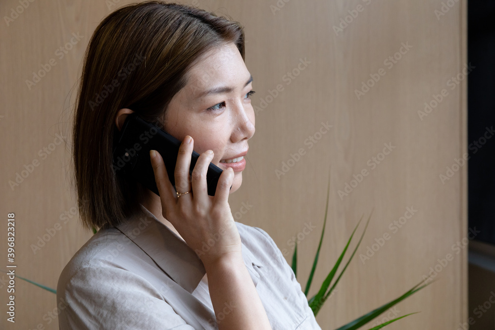 Asian businesswoman talking on smartphone in creative office Asian businesswoman talking on smartphone in creative office