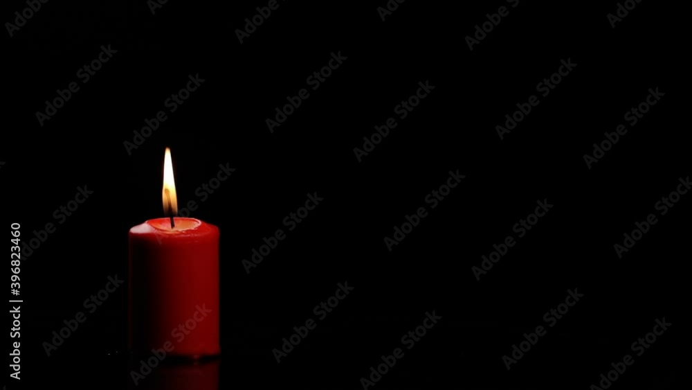 Red candle burns and goes out and gives a beautiful smoke on a black background Red candle burns and goes out and gives a beautiful smoke on a black background