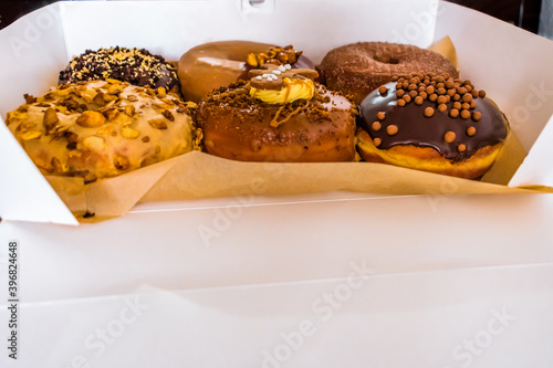 Perspective of box with sophisticated donuts with different toppings