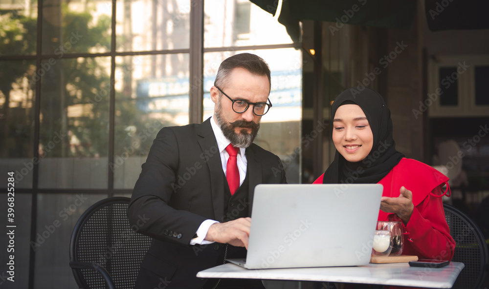 Caucasian businessman Negotiating business with a Muslim businesswoman