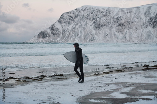 Photography Arctic surfer going by beach after surfing
