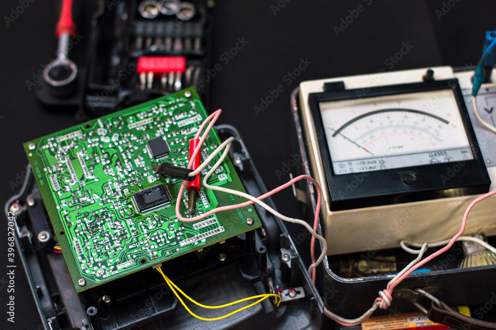 Technician repair electronic circuit board with soldering iron and tin wire. Technician repair electronic circuit board with soldering iron and tin wire.