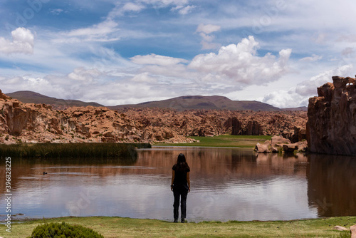 Back view of a woman in front of a scenic lake in the southwest of the Bolivian altiplano