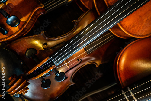 Close-up of a pile of violins on a diagonal.