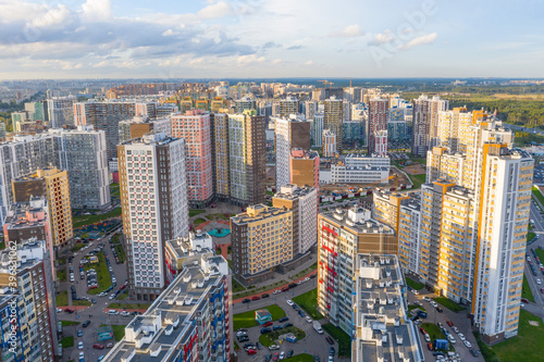 Panoramic aerial view of the city with multi-storey residential buildings and highways.