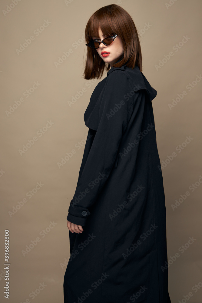 Funny woman classic coat good mood posing on a beige background 