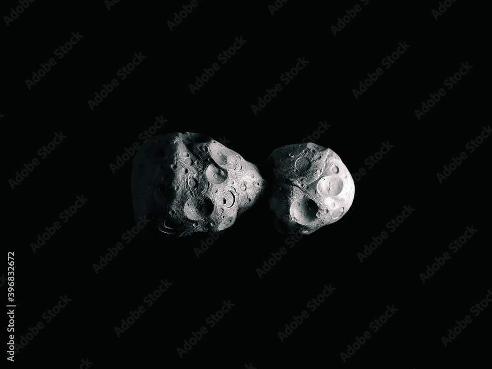Craters on the surface of an asteroid, large asteroid on a black background.