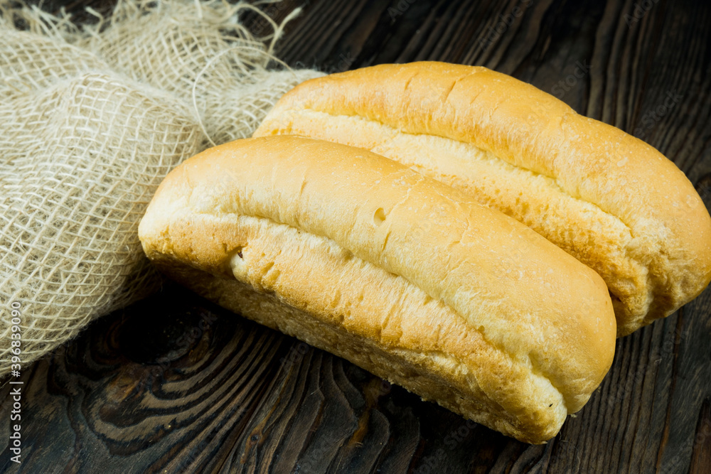 Close up of hotdogs bun on a sackcloth. hot dog rolls on a wooden background Close up of hotdogs bun on a sackcloth. hot dog rolls on a wooden background