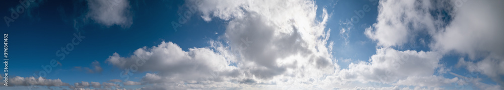 Blue sky with clouds in sunlight, wide cloudscape background panorama Blue sky with clouds in sunlight, wide cloudscape background panorama