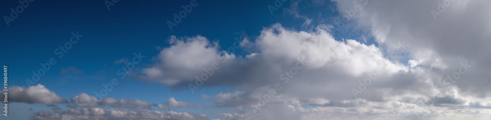 Blue sky with clouds in sunlight, wide cloudscape background panorama Blue sky with clouds in sunlight, wide cloudscape background panorama