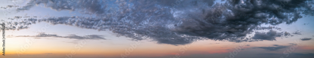 Fluffy clouds in evening sunset sky panoramic view. Climate, environment and weather concept cloudscape background.