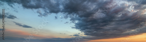 Fluffy clouds in evening sunset sky panoramic view. Climate, environment and weather concept cloudscape background.