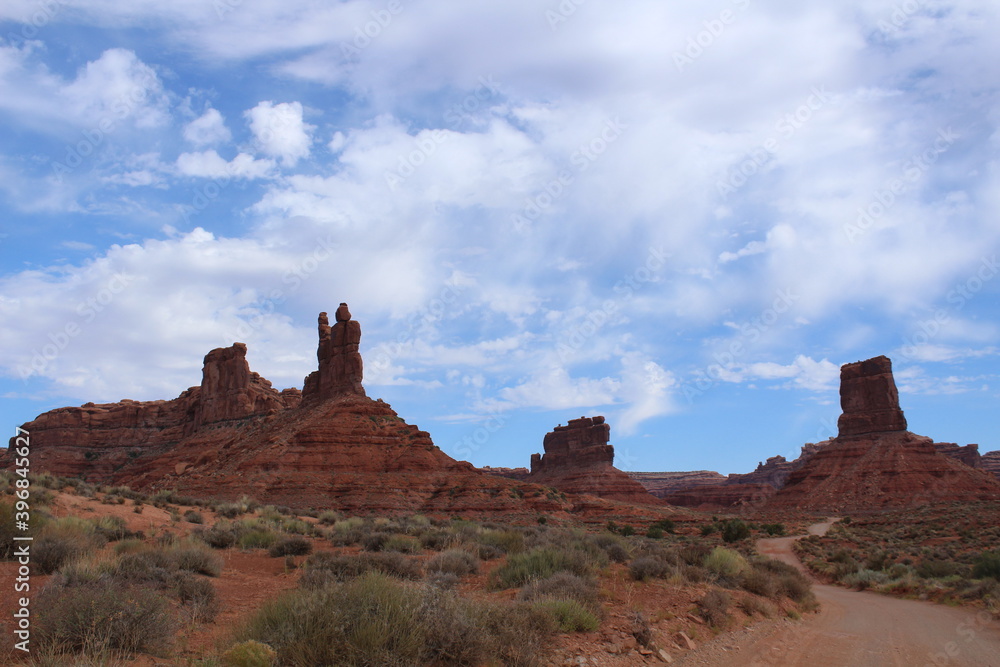 Large sandstone cliffs and colorful bright red wide plateaus make up the western Utah landscape; Valley of the Gods
