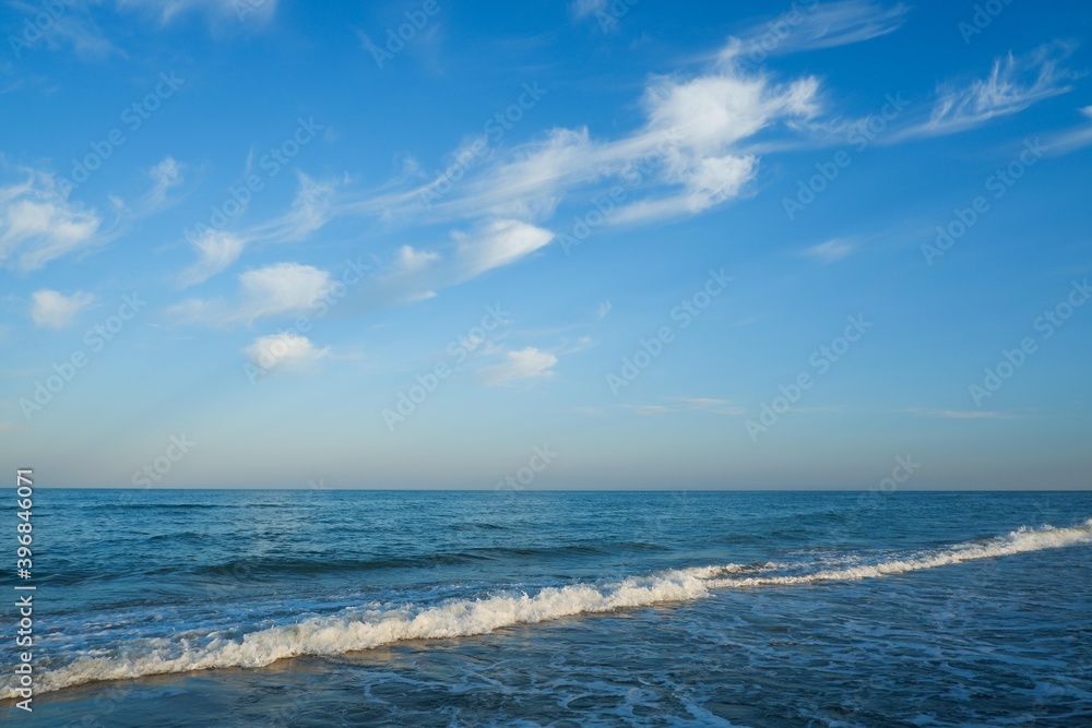 Sea beach with blue sky and yellow sand and some clouds