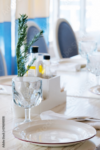 blurred background elegant table setting with white plate and crystal glass