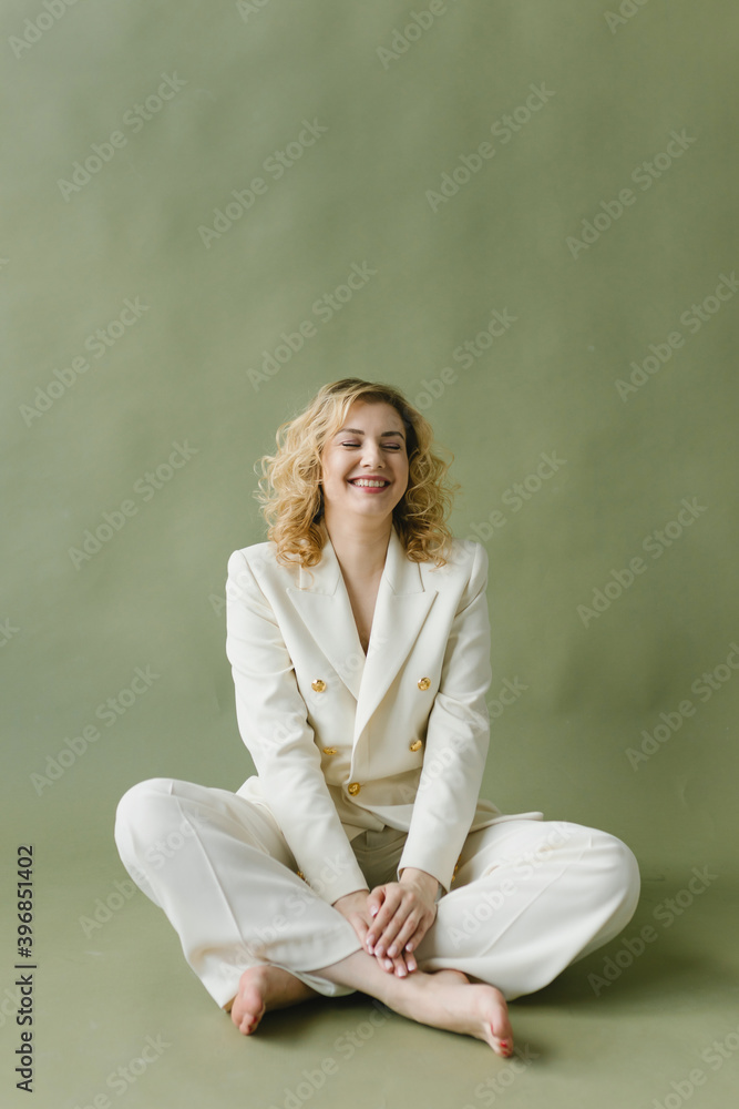 Portrait of a beautiful young woman in a white suit on an olive background. Portrait of a beautiful young woman in a white suit on an olive background.