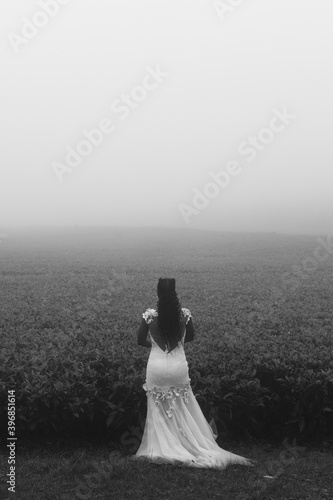 Woman Young Beautiful Lady Walking In Middle Of The Kenyan Highway Road On A foggy misty day in the morning at the Kiambu Limuru Highway Kiambu County Kenya East Africa photo