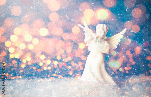 Christmas Angel Figurine and Blur Christmas Lights stock photo