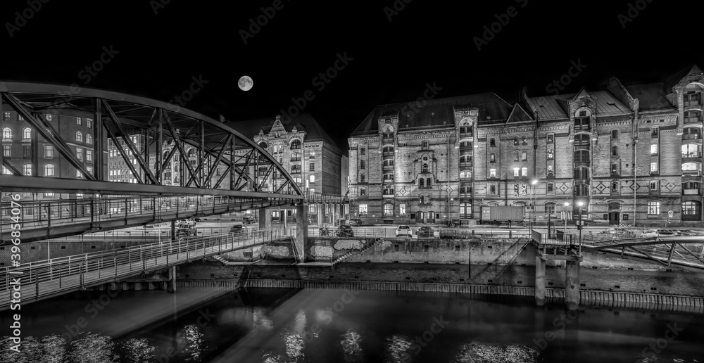 Hamburg, Germany. The Warehouse District (Speicherstadt) at night. View across the inner harbor (Binnenhafen) with the bridge 