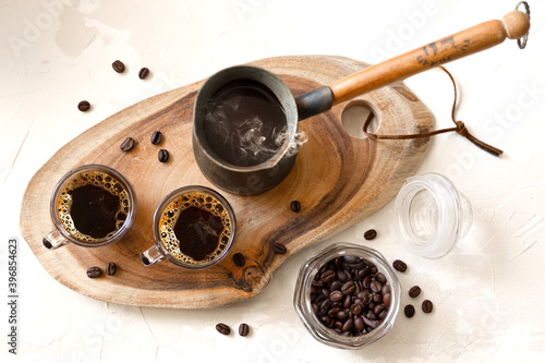 Finjan coffee pot and two espresso cups on a wooden stand, top view photo