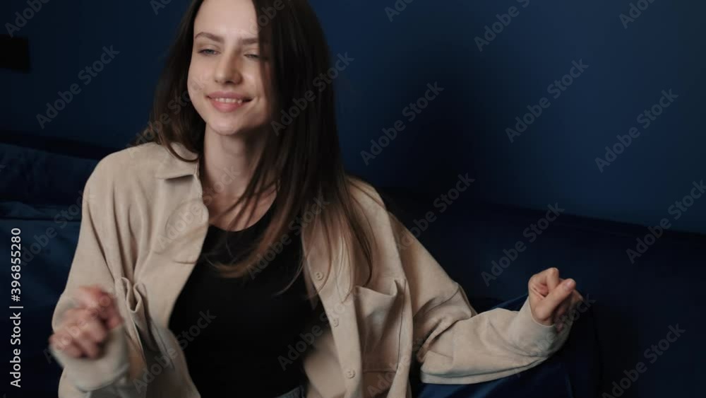 Woman dancing on sofa in apartment having fun alone feeling happy and carefree. Joyful young people and entertainment concept. Woman dancing on sofa in apartment having fun alone feeling happy and carefree. Joyful young people and entertainment concept.