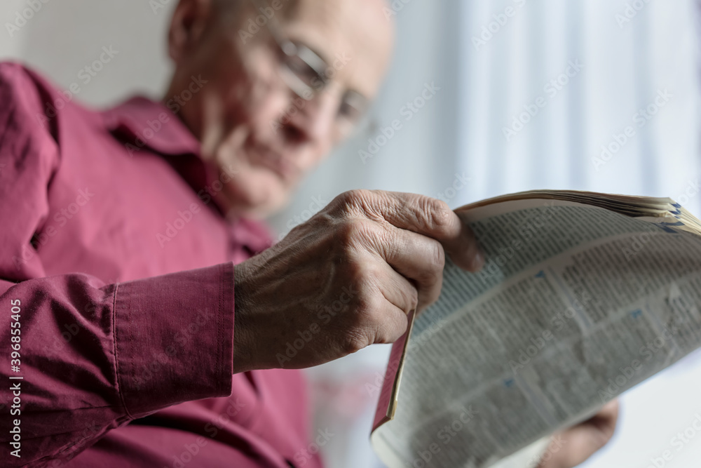 aged man holds in hands newspaper and reads news bottom view aged man holds in hands newspaper and reads news bottom view