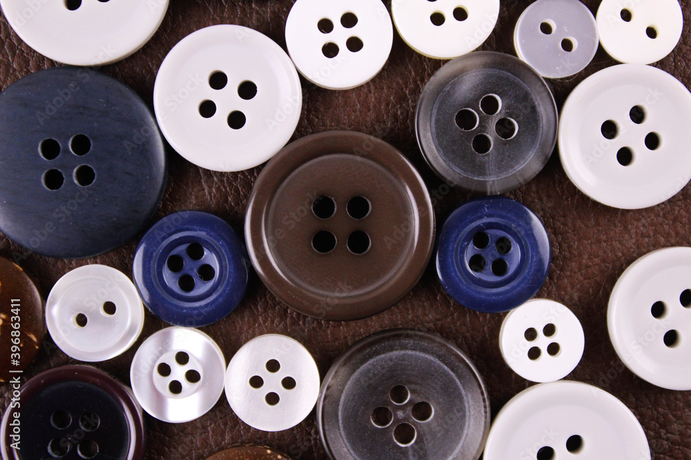 Set of different buttons on brown leather background Set of different buttons on brown leather background