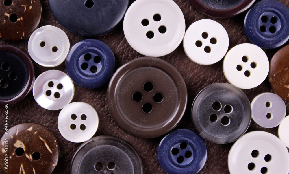 Set of different buttons on brown leather background Set of different buttons on brown leather background