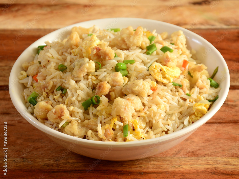 Indian cuisine Healthy and tasty chicken fried rice served in white bowl over a rustic wooden background, selective focus Indian cuisine Healthy and tasty chicken fried rice served in white bowl over a rustic wooden background, selective focus