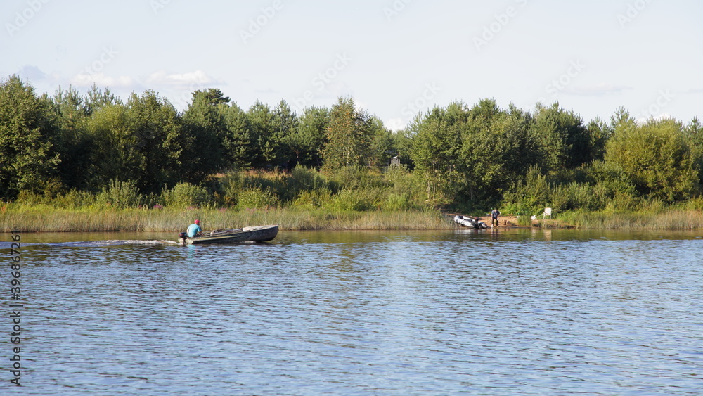 One old fishing motor boat floating near river shore with green forest on calm water background at summer day, scenery Russian natural landscape view from water, tourist camping outdoor recreation One old fishing motor boat floating near river shore with green forest on calm water background at summer day, scenery Russian natural landscape view from water, tourist camping outdoor recreation