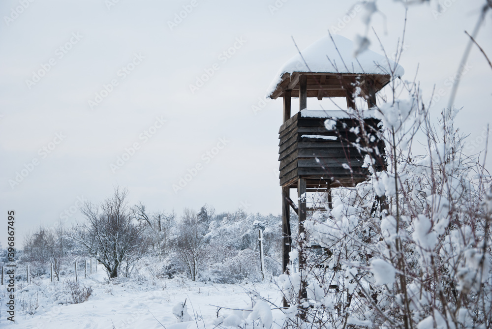 Wooden hunting tower in forest in winter snowy time Wooden hunting tower in forest in winter snowy time
