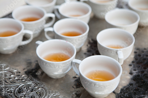 filled white tea cups on silver platter