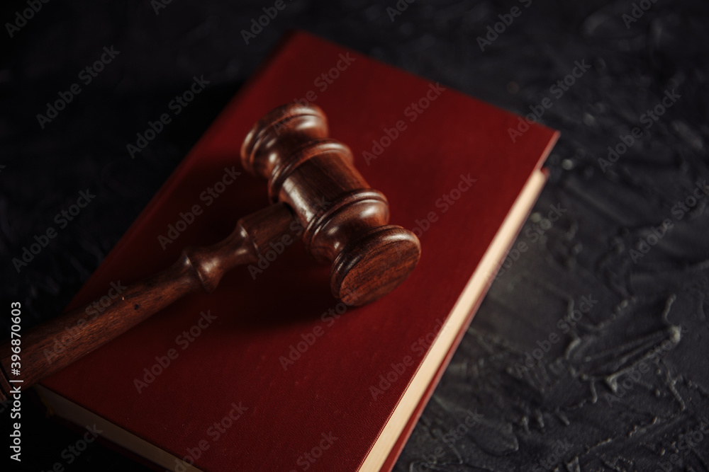 Judge gavel with red book on a table.