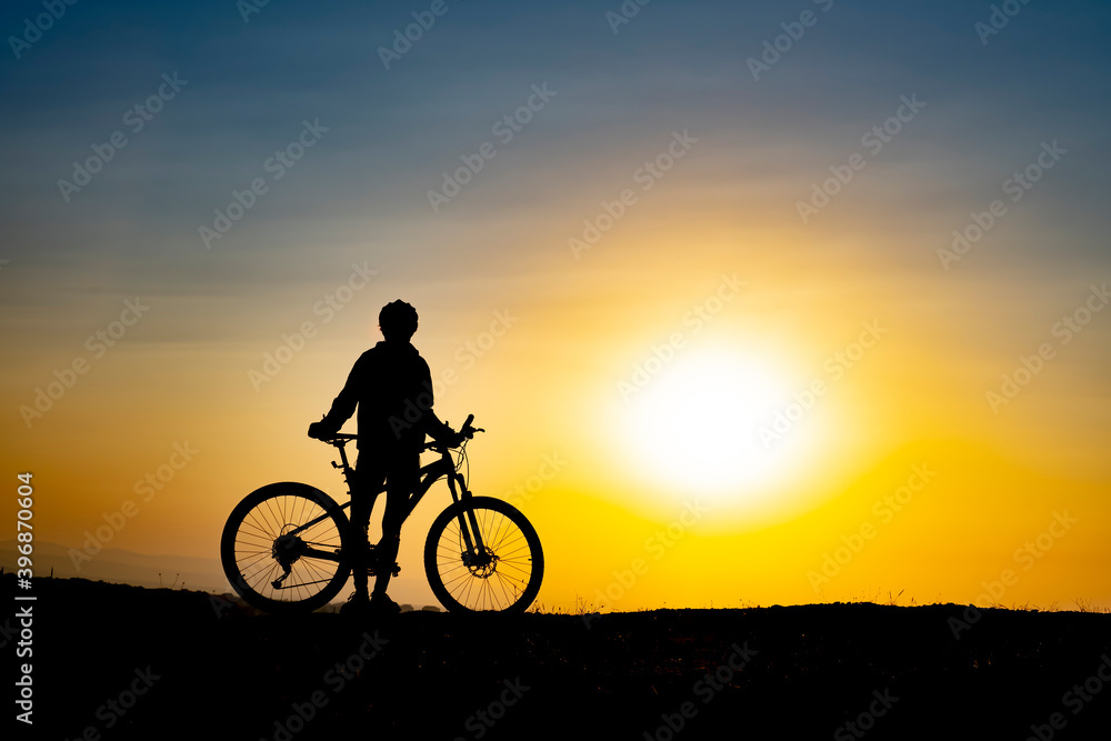 The moment of the cyclist enjoying nature watching the sunrise The moment of the cyclist enjoying nature watching the sunrise